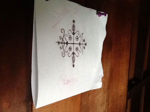 Voodoo Symbol on a piece of paper hung on the wall of Papa Legba