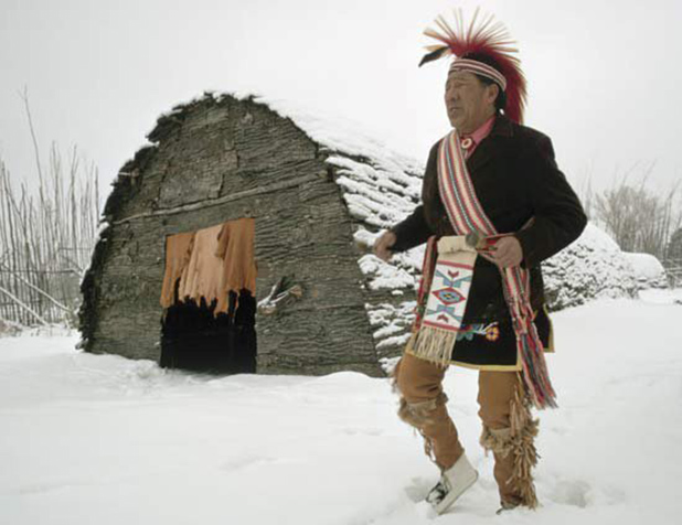 Native American Sachem in front of longhouse